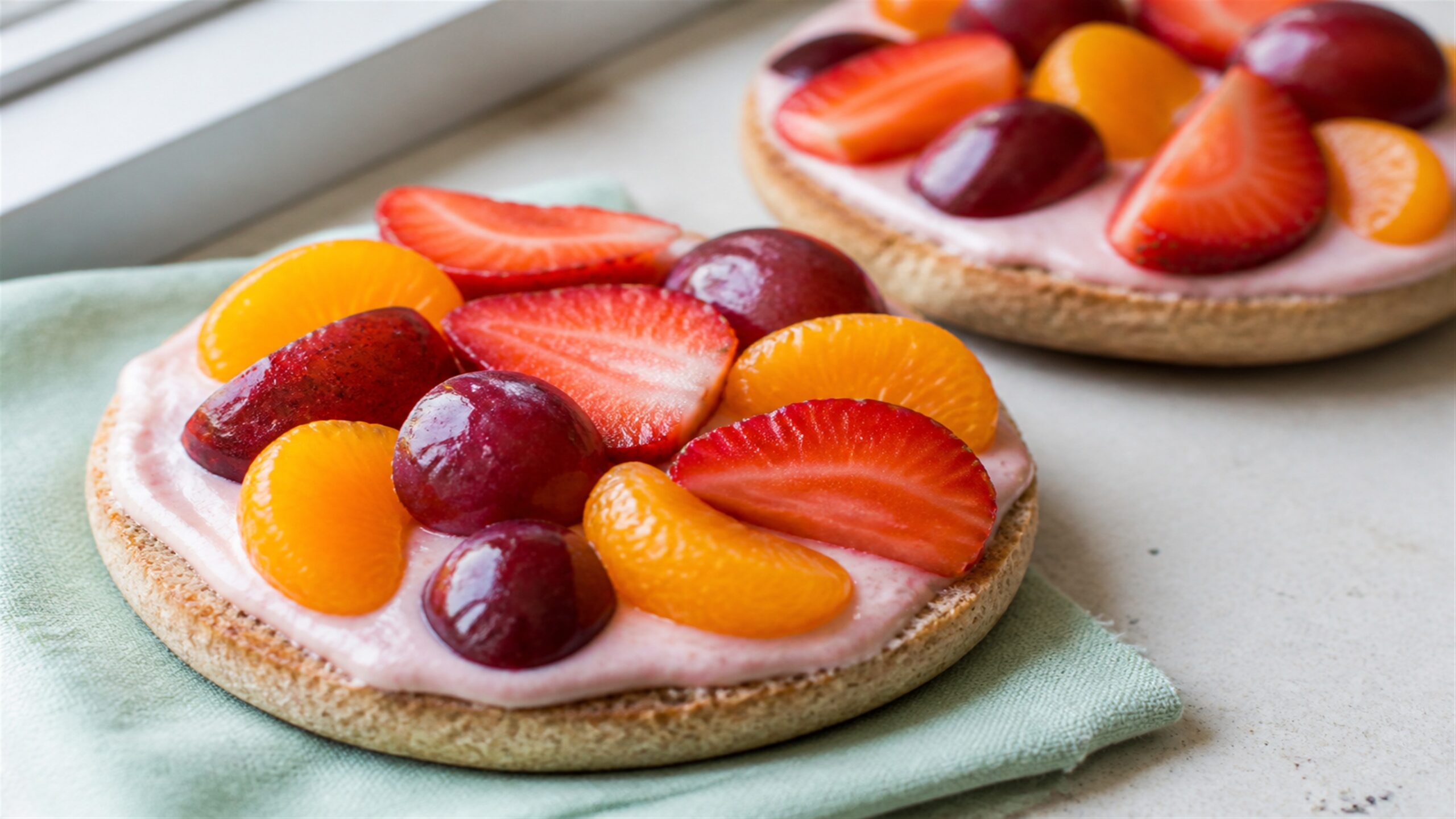 Whole-wheat English muffin fruit pizzas with strawberry cream cheese, strawberries, grapes and mandarin oranges